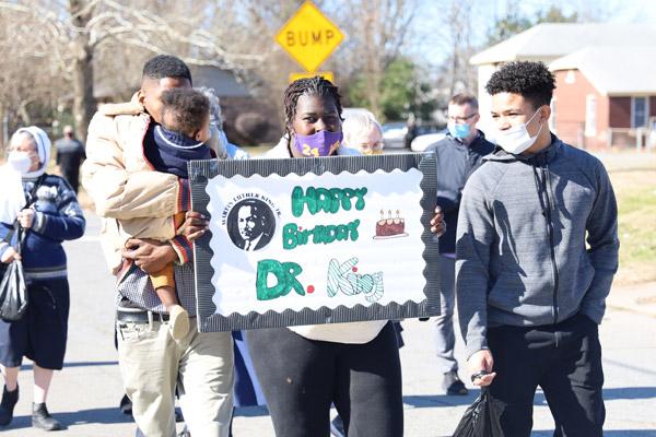 St. Augustine parishioner Allen Anderson (left) carries son Mason while his wife Shareka Anderson holds a sign during the march. The family was joined by nephew Cyntonio Dicus of North Little Rock (right). (Dwain Hebda photo) 