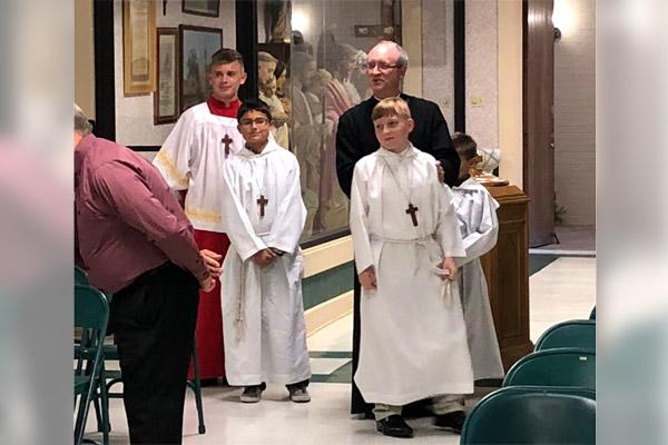 Father James West stands with altar servers Christopher Sharpe (left), Issac Gandolph, Josh Sharpe and Dillion Gandolph in April 2018 at St. Edward Church in Texarkana. Father West, who died last year, had a close connection to his altar servers. (Courtesy Brenda Engel)