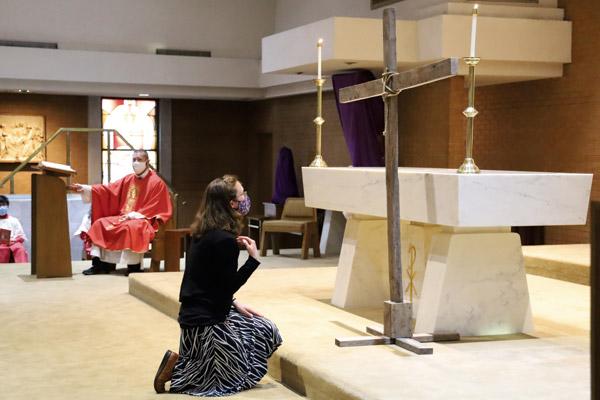 A parishioner kneels to venerate the cross during April 2 Good Friday services at Our Lady of Good Counsel Church in Little Rock. (Dwain Hebda photo) 