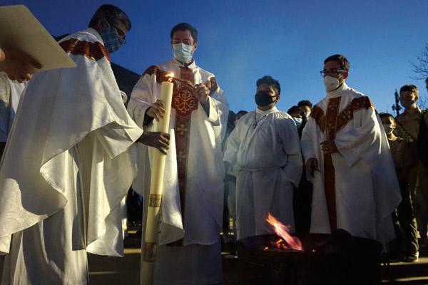 Associate pastor Father Balaraju Desam holds the paschal candle as pastor Father Tony Robbins lights it from the fire in front of St. Joseph Church in Conway during the Easter Vigil April 3. Associate pastor Father Joseph de Orbegozo is also seen at right. (Aprille Hanson Spivey photo) 
