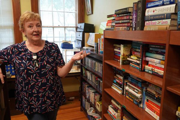 St. Edward parishioner and volunteer Vicki Morgan shows off the book collection at the St. Edward Thrift Store in Little Rock. Morgan said the evolution of the nearby community has made the thrift store important for the local low-income and elderly. (Aprille Hanson Spivey photo)
