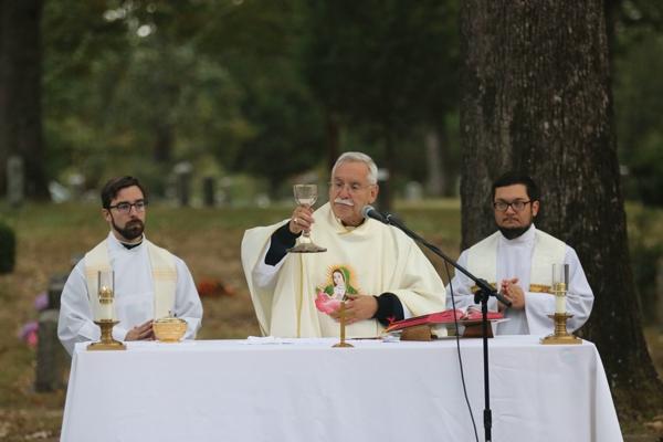 Bishop Anthony B. Taylor celebrates the Liturgy of the Eucharist as Father Joseph L. de Orbegozo, and Father Stephen Elser, look on at the All Souls Mass at Calvary Cemetery in Little Rock Nov. 2. (Photo Chris Price)