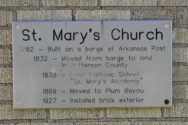 A plaque on the exterior wall of St. Mary Church at Plum Bayou chronicles the church's construction and history, dating back to 1782. Photo by Chandler Bartel.