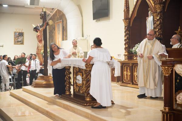 Parishioners at St. Barbara Church in De Queen dress the altar with linens after Bishop Anthony B. Taylor blessed it Sept. 2. The parish converted their parish center into a church following a large increase in attendance. Courtesy Father Ramsés Mendieta.