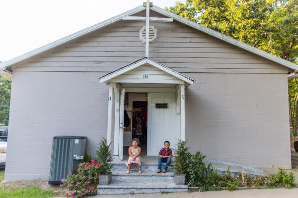Second-grader Leani Hernandez and first-grader Adoldo Eliazar sit on the front steps of Blessed Stanley Rother Church in Decatur July 29. Travis McAfee.