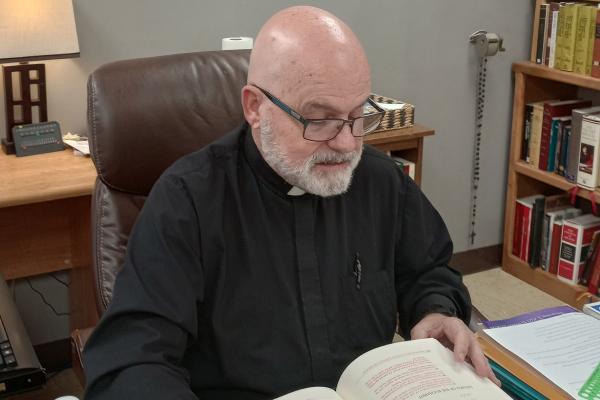 Father Norm McFall reads in his office March 7 at Sacred Heart Church in 
Charleston. He is bringing Catholic in Recovery to his parish and inviting 
Catholics in the region to join the ministry. (Courtesy Father Norm McFall)