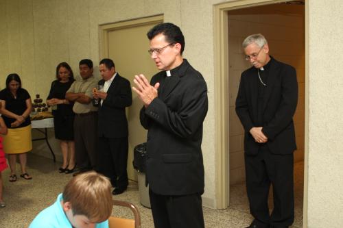 Rick Hobbs, newly ordained a transitional deacon, leads a prayer with well-wishers at a reception following Mass. Karen Schwartz photo