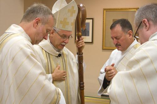 Msgr. Scott Friend, vocations director, Bishop Anthony B. Taylor, Deacon George Sanders and Father Dennis Robinson, OSB, pray before Sanders’ ordination Mass. Bishop Taylor has ordained 12 priests in the past five years. Bob Ocken photo