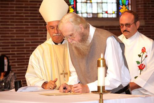 David Menkhoff signs his plan of life before Bishop Taylor. Malea Hargett photo