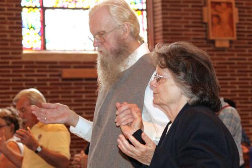 Hermits David Menkhoff and Judith Weaver hold hands during the sign of peace Sept. 10. Malea Hargett photo
