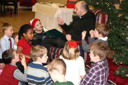 Father Matthew Garrison reads the Story of St. Nicholas to children at the annual St. Nicholas Party hosted by the Cathedral of St. Andrew on Dec. 14. St. Nick’s parents died while he was young. He became known for his generous heart, giving his inheritance to the poor and suffering and later became the Bishop of Myra. (Photo by Aprille Hanson) 