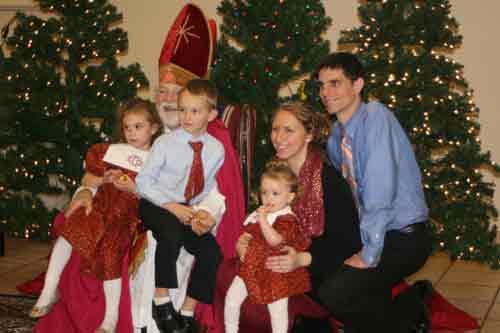 St. Nicholas poses with the Osborne family, parishioners of the Cathedral of St. Andrew, at the annual St. Nicholas Party Dec. 14. From left: Emily, 5; Paul, 6; Mary, 7 months; parents, Alicia and Paul Osborne. (Photo by Aprille Hanson)