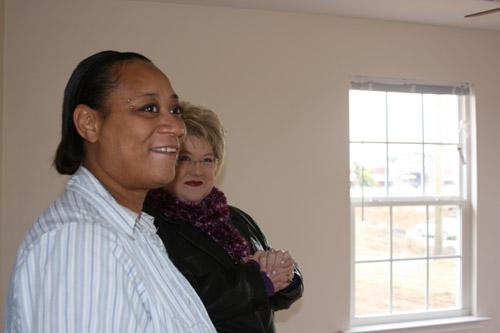 Mary Garcia (left) looks around her new house with Tracy Eichenberger, disaster preparedness and response coordinator for Catholic Charities of Arkansas. (Aprille Hanson) 