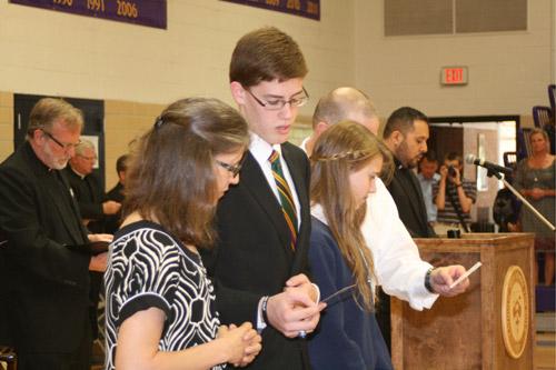 John Paul Hartnedy and his family read a prayer for vocations. In a ceremony mirroring the signing of a student to a university’s athletic team, Catholic High celebrates graduating seniors who are joining the seminary with a signing day celebration. Hartnedy was the only senior this year to commit. (Aprille Hanson)