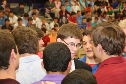 Fellow seniors hug and offer words of support to John Paul Hartnedy, the only graduating senior to sign a letter of intent to become a seminarian this fall. (Aprille Hanson)