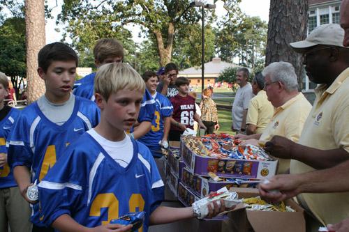Gavin Pauley, a football player with Immaculate Conception School in North Little Rock, grabs a hot dog with his teammates from the Knights of Columbus at the rosary rally. (Aprille Hanson)
