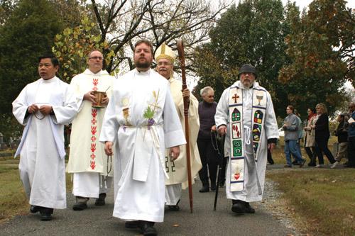 Father Jason Tyler, pastor at St. Edward Church in Little Rock, leads a rosary procession through Calvary Cemetery after Mass Nov. 2. From left are Father Jack Vu, Deacon Tim Costello, Bishop Taylor and Father Thomas Keller. (Aprille Hanson photo)
