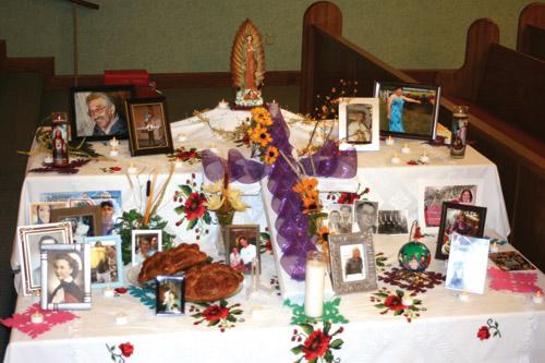 The Day of the Dead altar, set up by the Hispanic Commission at St. Joseph Church in Conway for the All Souls Day Mass, featured photos of parishioners loved ones as well as traditional items, like bread known as "pan de muerto." (Aprille Hanson photo) 
