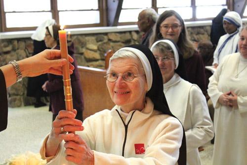 Sister Elaine Willett, OSB, of Holy Angels Convent in Jonesboro, receives her candle during a Mass celebrating the Year of Consecrated Life at the Carmelite Monastery in Little Rock Feb 14. (Dwain Hebda photo)