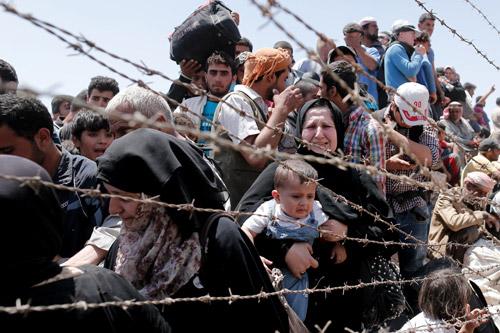 Syrian refugees wait on the Syrian side of the border near Sanliurfa, Turkey, June 10, 2015. Bishop Eusebio Elizondo, chairman of the U.S. Conference of Catholic Bishops’ Committee on Migration, says the United States should welcome Syrian refugees and work for peace. (CNS / Sedat/Suna, EPA. Prints not available for this photo)