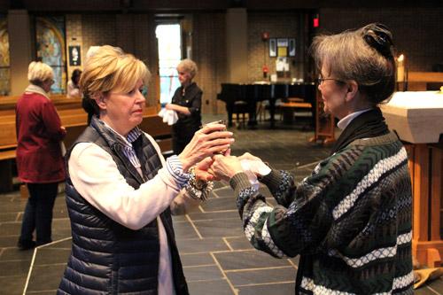 Nancy Mack offers consecrated wine to worshipers during Mass March 5 at Our Lady of the Holy Souls Church. The Mass was followed by a series of guided prayers and mediations as part of the parish’s 24-hour vigil. (Dwain Hebda photo)