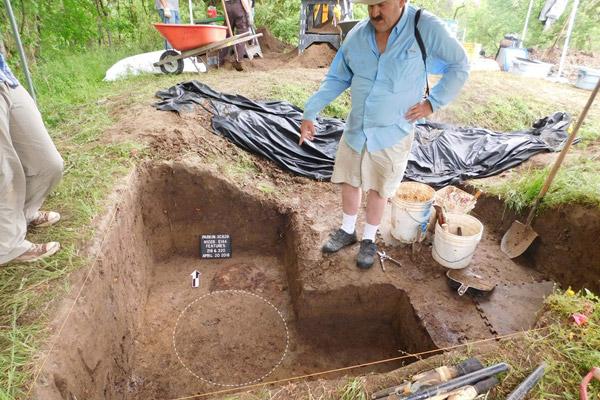 Archaeologist Jeffrey Mitchem, who has waited since 1992 to uncover the remains of what they believe could be a cross from Hernando de Soto’s expedition, points to the pattern of the post hole just below where it was removed from the mound. (Jessica Crawford photo, The Archaeological Conservancy)
