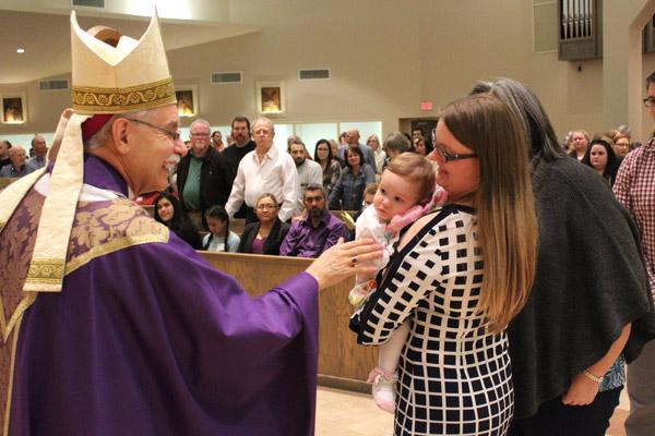 Bishop Anthony B. Taylor gives a blessing to a sleepy toddler during the Rite of Election March 5 in Little Rock. (Dwain Hebda photo)