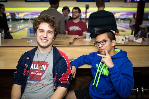 Todd Fernandez flashes the peace sign while sitting with friend Sam Johnson while bowling with fellow parishioners. (Travis McAfee photo)