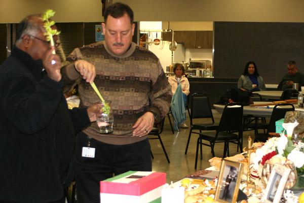 Father George Sanders (left), pastor of St. Mary of the Springs Church in Hot Springs, dips a celery stalk into holy water to bless the St. Joseph altar on March 16 along with Father Chinnaiah Irudayaraj “Y.C.” Yeddanapalli, pastor at St. John Church. (Aprille Hanson photo)