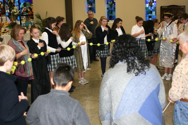 St. John School students pray with a life-size rosary made of tennis balls after the St. Joseph altar blessing at St. Mary Church. (Aprille Hanson photo)