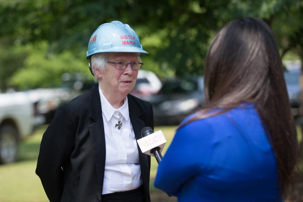 A local television reporter interviews prioress Sister Maria DeAngeli after the ceremony.