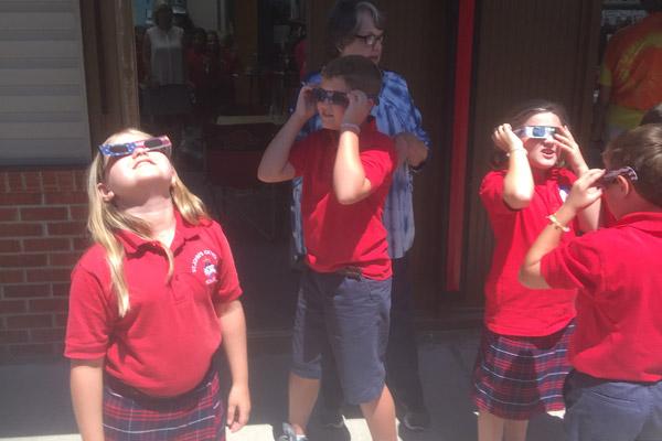 Students at St. John School in Russellville watch the solar eclipse.