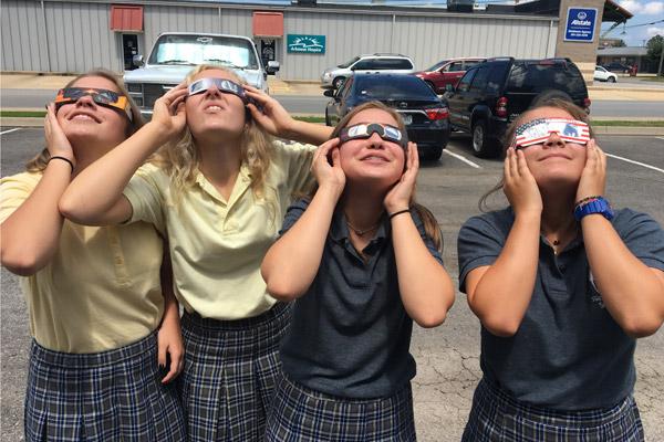 Young students at St. Joseph School in Conway smile while watching the eclipse. 