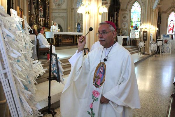 Bishop Taylor blesses panels bearing prayer intentions to Mary Undoer of Knots Sept. 30 in Little Rock. (Dwain Hebda photo)