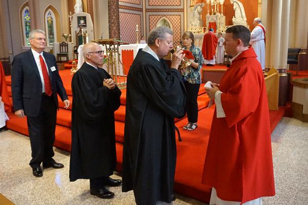 St. Francis County District Judge Steve Routon receives communion from Deacon Matthew Glover, diocesan chancellor for canonical affairs. (Aprille Hanson photo)
