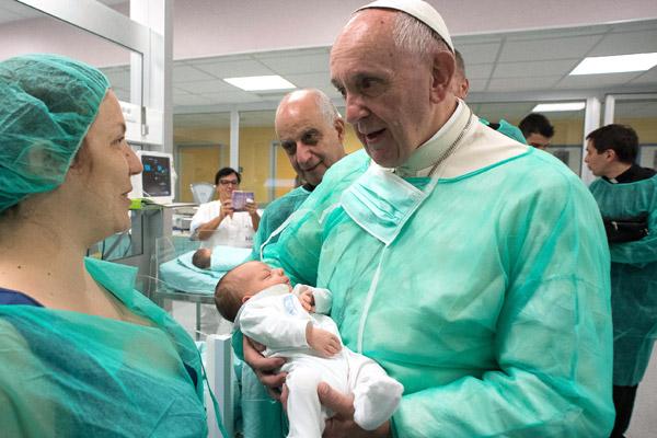 Pope Francis holds a baby as he visits the neonatal unit at San Giovanni Hospital in Rome in this Sept. 16, 2016, file photo. The visit was part of the pope's Friday works of mercy. (CNS photo/L'Osservatore Romano)