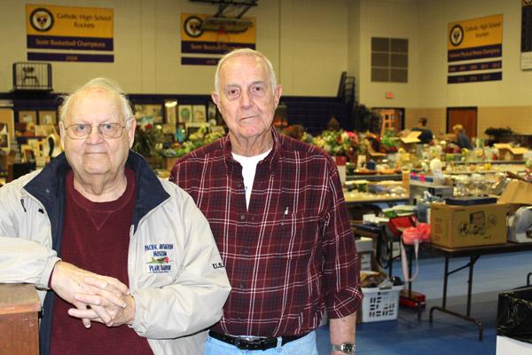Jim Barre (left) and Larry Wilson take a break from setting up the Catholic High Junktique garage sale. The two CHS grads have been volunteering with the annual event for about 40 years. (Dwain Hebda photo)