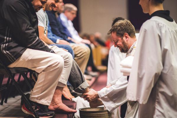 Pastor Father Jason Tyler washes the feet of parishioners of St. Joseph Church in Fayetteville on Holy Thursday in imitation of Jesus. (Travis McAfee photo)