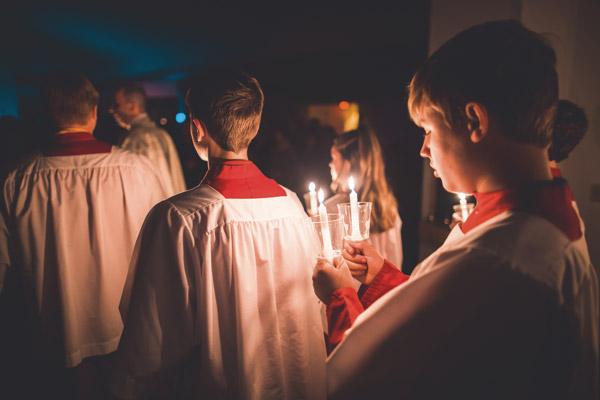 Altar servers hold candles as they enter the darkened church at 8 p.m. Holy Saturday at St. Joseph Church in Tontitown. The Mass begins with the lighting of the new Paschal candle and then lighting candles of parishioners. (Travis McAfee photo)