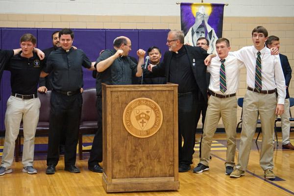 Catholic High alumni sway to the alma mater. Pictured are seminarian Aubrey Volpert (who signed last year to the seminary from Catholic High); Father Tony Robbins; Father Greg Luyet; Msgr. Scott Friend, diocesan vocations director; and seniors Joseph Jones and Thomas DePrez, who were this year’s signees. (Aprille Hanson photo)