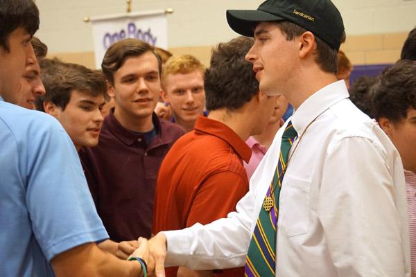 Thomas DePrez shakes hands with his fellow seniors following the signing day ceremony May 1. (Aprille Hanson photo)