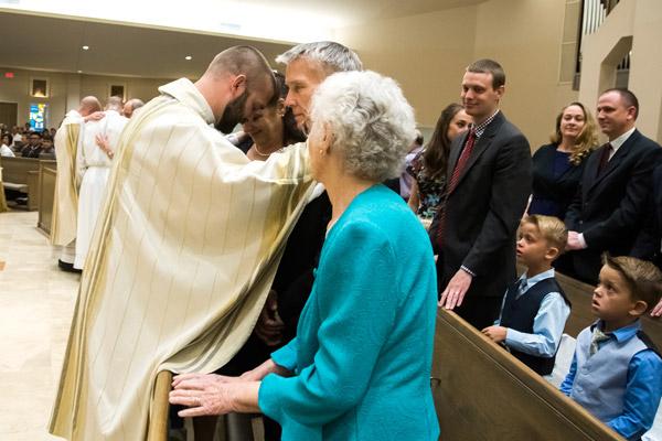 At the conclusion of his ordination Mass, Father Jeff Hebert prays over his family May 26. (Bob Ocken)