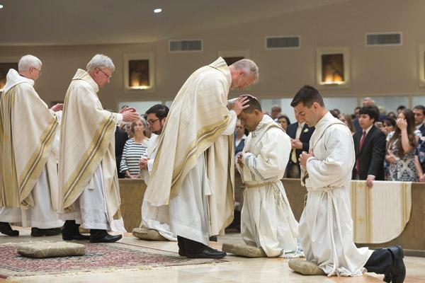 On June 2 Msgr. Scott Friend, vocations director, and other priests lay hands on Father Daniel Ramos and the other new priests as a sign of episcopal unity. (Bob Ocken)