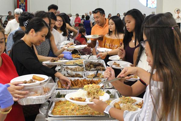 Congregants load up on Filipino delicacies following the Mass to honor San Lorenzo Ruiz and San Pedro Calungsod, patron saints of the Phillippines at the Cathedral of St. Andrew Sept. 16. (Dwain Hebda photo)
