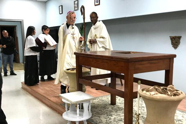 Bishop Anthony B. Taylor blesses the altar as Father Eliseo Noel Njopmo, associate pastor at St. Joseph Church in Fayetteville and Sts. Peter and Paul, watches. Ana Martinez and Luis Calvillo served at the altar. (Tania Herrera photo)