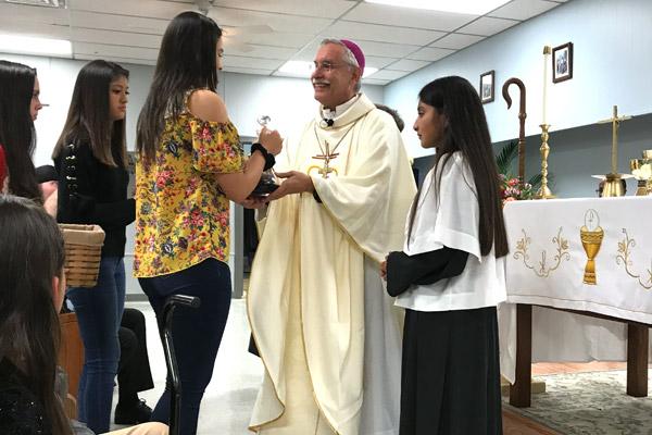 Brianna Saldaña (left), Estefany Ruvalcaba and Hailey Saldaña bring the gifts up to the altar for Bishop Anthony B. Taylor and altar server Ana Martinez at the new Sts. Peter and Paul Church, during the first Mass at their permanent building Oct. 20. (Tania Herrera photo)