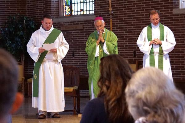 Deacon Matt Glover (left), chancellor for canonical affairs, reads the list of intentions for those who have suffered sexual abuse during an Aug. 31 Mass for diocesan employees in Little Rock. (Aprille Hanson / Arkansas Catholic file)