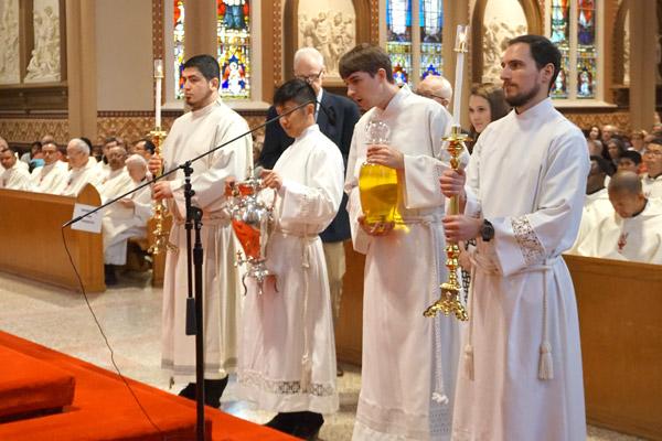 Seminarians present the oil of the sick for Bishop Anthony B. Taylor to bless at the Chrism Mass April 15. Seminarians pictured are: Omar Galván (left), Tuan Do, Thomas de Prez and Ben Riley. (Aprille Hanson photo)
