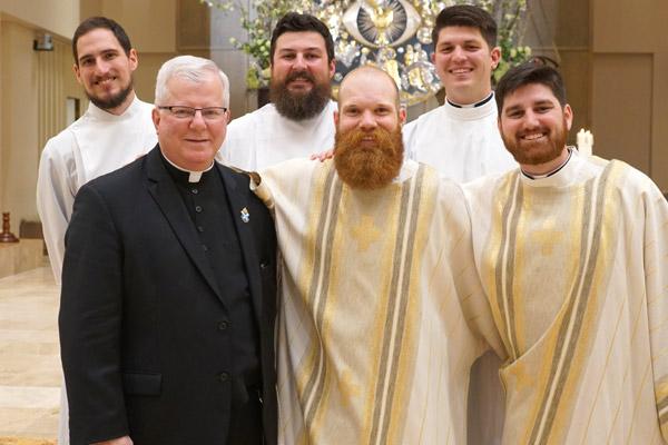 Pastor Msgr. Francis Malone poses with the five seminarians from Christ the King Church in Little Rock. They are Ben Riley (back row, from left,) Brian Cundall and Daniel Wendel; Deacon Joseph Friend (front row, center) and Deacon Jon Miskin, who was ordained a priest May 25. (Malea Hargett pho-to)