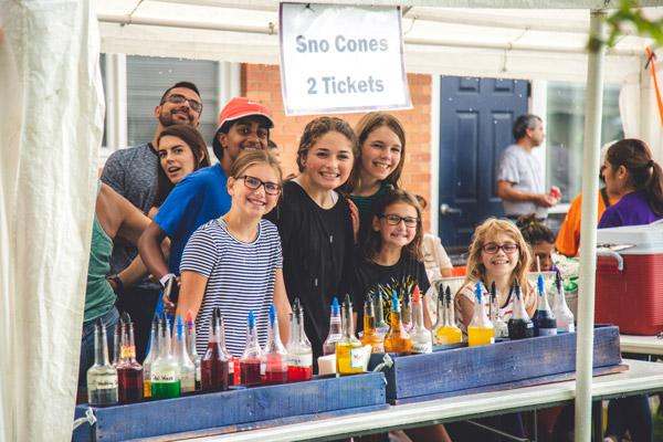 Young parishioners serve up snow cones as a good way to beat the heat during Summerfest. (Travis McAfee photo)